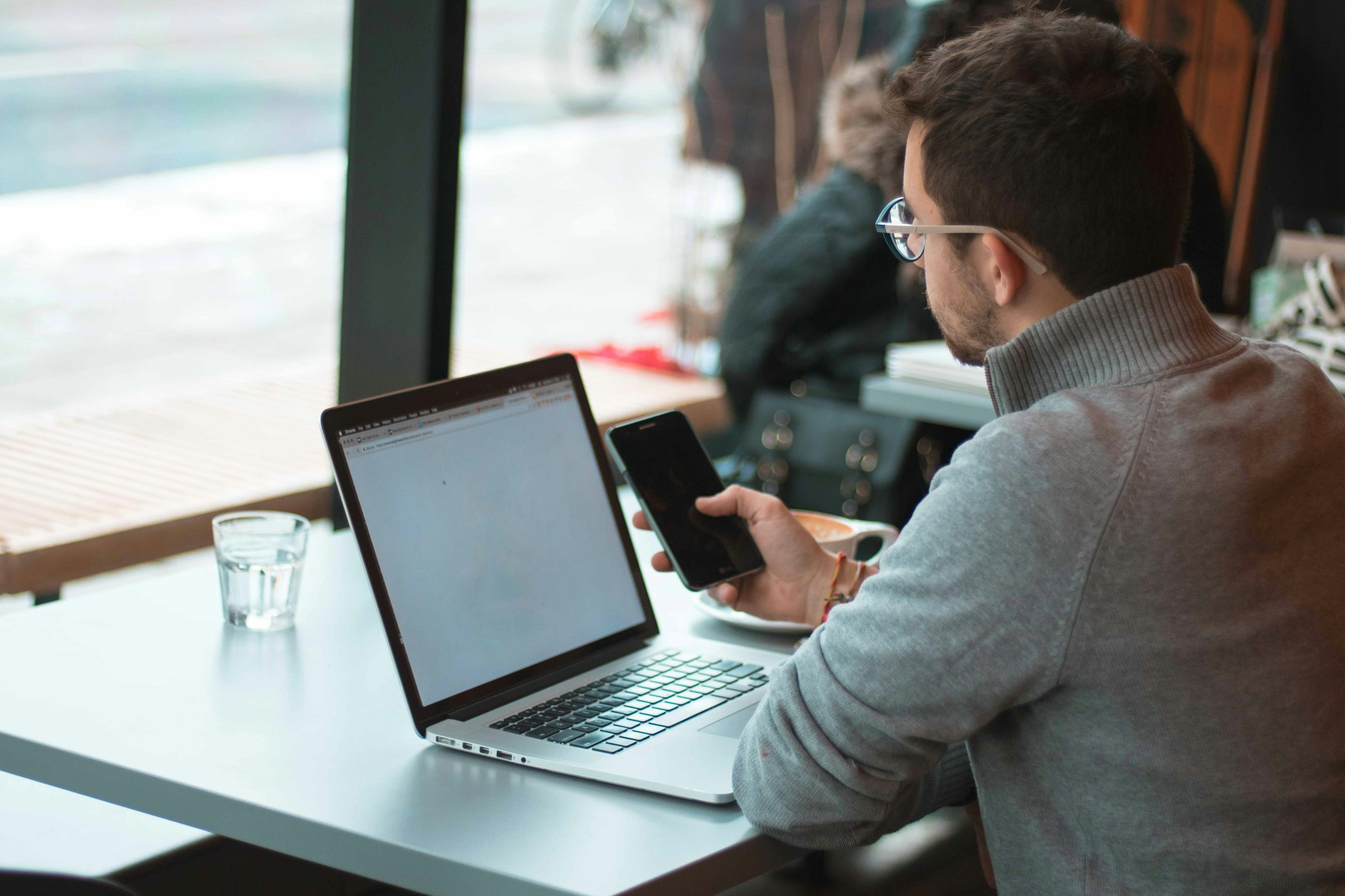 Focused business owner at a laptop by a window — the kind of decision-making moment that leads clients to DEM.
