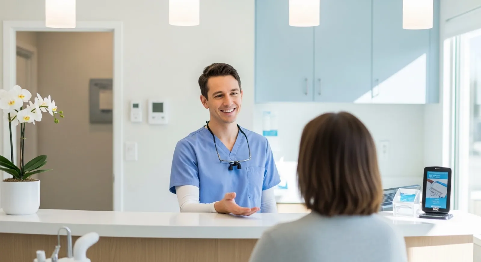 Friendly dentist greeting a patient at the reception of a bright, modern dental clinic